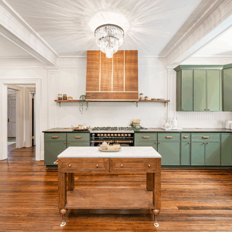 Ilve Nostalgie range in a kitchen, partially covered by an island, but with its knobs, handles, and gas top visible.